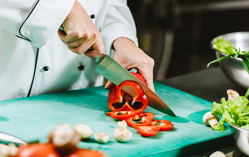 Chef cutting vegetables on chopping board