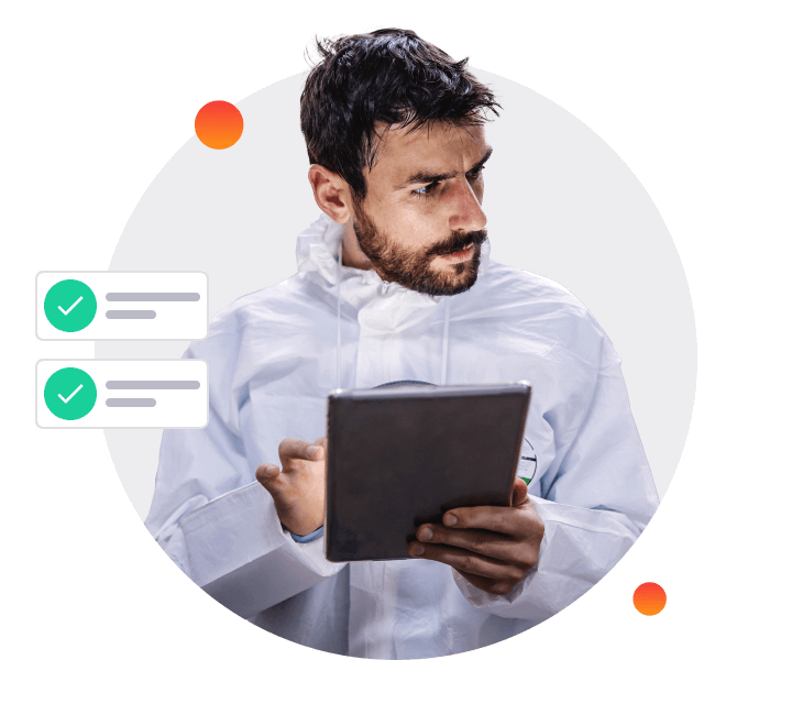 Worker in a protective coverall reviewing a tablet, with two green checkmark compliance items shown beside him.